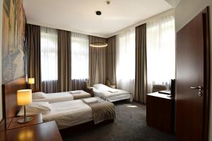 克拉科夫Hotel Downtown Kraków的酒店客房设有两张床和电视。