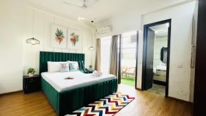 诺伊达Olive Service Apartments - City Centre Noida的一间卧室配有一张带绿色床头板的床