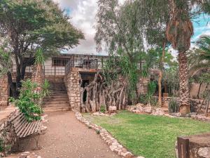 KangNkisi Guesthouse的一个带石头走道和树木的花园