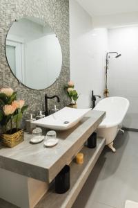 桑托斯将军城Monica Midtown Suites的一间带大镜子和盥洗盆的浴室