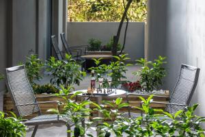 海若克利欧Kipos Boutique Suites的庭院设有两把椅子和一张植物桌子