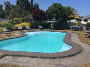 陶波陶波湖区度假酒店的一座大型游泳池,四周有砖砌的走道