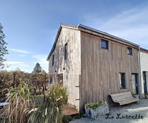 力宾Holiday home le Lurçon et la Lurcette的旁边设有长凳的小型木制建筑