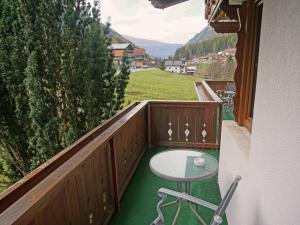 OberlehnApartment Alpengruss by Interhome的阳台配有桌子,享有田野美景