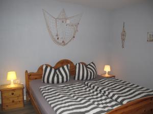 乌曼茨Holiday Home Ostwind by Interhome的一张带黑白枕头的床和两盏灯