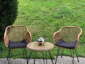 南达Apartment Eden Roc 53 by Interhome的两张椅子和一张桌子,上面装有茶壶