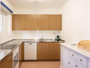 圣莫里茨切萨丹妮拉B公寓 - 阿妮塔的厨房配有木制橱柜和白色洗碗机。