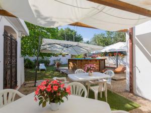 阿特里Holiday Home Le Querce - PIT550 by Interhome的庭院配有白色的桌子、白色的椅子和遮阳伞