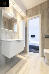 圣朱利安斯Penthouse with BBQ Kitchen Island & Massive Living room by 360 Estates的一间带水槽和卫生间的浴室以及窗户。
