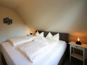 勒伯尔Apartment Müritz Ferienpark Röbel-8 by Interhome的一张带白色床单和枕头的床
