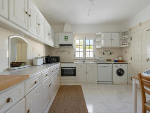 维拉摩拉Villa Villa Verde by Interhome的一间白色的大厨房,配有白色的橱柜和电器