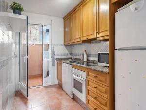 莫哈卡尔Apartment Marina de la Torre by Interhome的厨房配有白色家电和木制橱柜