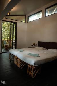 瓦亚纳德Uravu Bamboo Grove Resort的配有窗户的客房内的一张大床