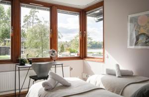TyresöExclusive Lakefront Mansion with pools in Stockholm的客房设有两张床、一张桌子和一个窗户。