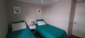 康康Maravilloso departamento con vista panorámica.的小客房内的两张床,配有绿色床单