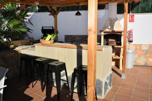 奥利维拉Villa Lluna Sitges 15 minutes drive from Sitges Swimming pool XXL 16 people的厨房设有带凳子和壁炉的酒吧。