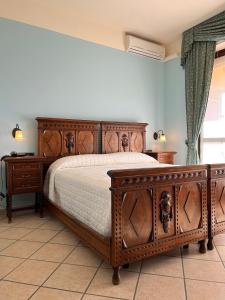 MontàBelvedere Bike Hotel的一间卧室配有木床和2个梳妆台。
