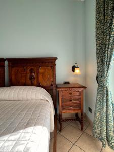 MontàBelvedere Bike Hotel的一间卧室配有一张床和一个带灯的床头柜