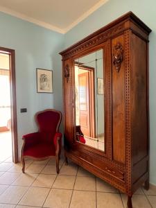 MontàBelvedere Bike Hotel的椅子和带镜子的木制橱柜