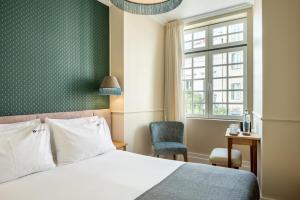 里斯本Boemio FLH Hotels的卧室配有床、椅子和窗户。