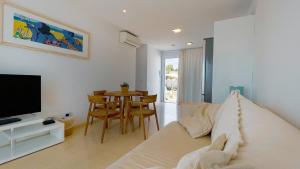 卡兰博希Lago Resort Menorca - Villas & Bungalows del Lago的客厅配有床、电视和桌子