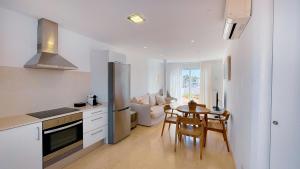 卡兰博希Lago Resort Menorca - Villas & Bungalows del Lago的厨房以及带桌子和冰箱的用餐室