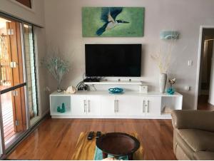 萨武萨武Island Breeze Fiji的一间客厅,客厅内配有一台电视,位于白色娱乐中心