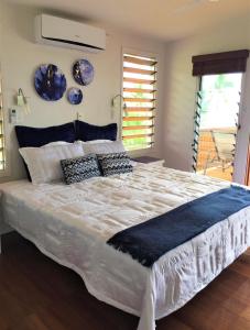 萨武萨武Island Breeze Fiji的卧室配有一张大白色床,墙上挂着蓝色板