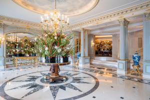日内瓦日内瓦贝尔格四季酒店的大型大堂的地板上设有吊灯和鲜花
