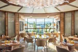 日内瓦日内瓦贝尔格四季酒店的餐厅设有桌椅和大窗户。