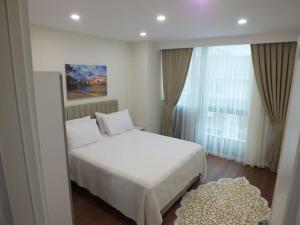 伊斯坦布尔Central Cozy Flat with Terrace & Sea View的卧室设有白色的床和大窗户