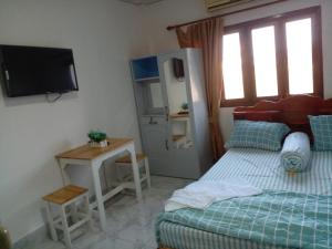 万象Ban Saylomleng Residence的一间卧室配有一张床、一张桌子和一台电视