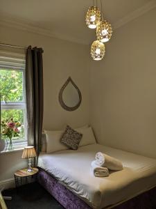 南安普敦Blue Keys Hotel Southampton的一间卧室配有一张带窗户和镜子的床