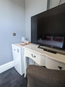 南安普敦Blue Keys Hotel Southampton的一张白色的桌子,上面有一台电视