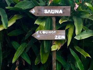 圣吕斯Eden Paradise Ecolodge & Spa的树上写着sumka的标志和休息