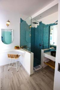 易莫洛林卡尔德拉马杰斯提别墅的带淋浴、椅子和桌子的浴室