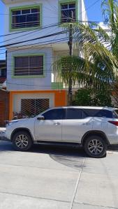 伊基托斯100 RV Apartments Iquitos-Apartamento primer piso con vista a piscina的停在房子前面的银色汽车