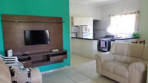 伊利亚孔普里达Casa Pestana - Ilha Comprida的带沙发和电视的客厅以及厨房。