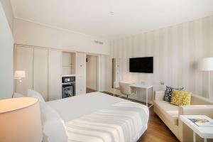都灵NH都灵中心酒店的酒店客房配有白色的床和沙发。