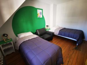圣卡洛斯-德巴里洛切Cinerama Hostel的一间卧室设有两张床和绿色的墙壁