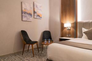 Sīdī Ḩamzahفندق ركاز الماسي - Rekaz Diamond Hotel的酒店客房,配有一张床和两把椅子