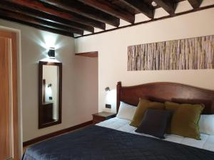 洛斯雷亚莱霍斯卡萨布兰卡乡村酒店的一间卧室配有一张带木制床头板和镜子的床