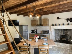 Gîte Val-de-Bonnieure, 3 pièces, 4 personnes - FR-1-653-214的厨房配有木桌、椅子和壁炉