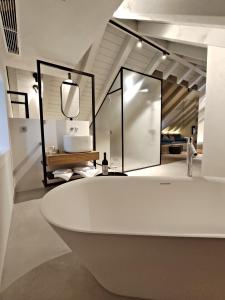 科尔丘拉Zuviteo Residence的浴室配有白色浴缸和镜子