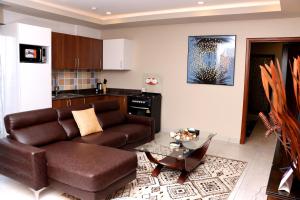 阿克拉Montecito Apartments的客厅配有棕色沙发和桌子