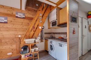 EnchastrayesL'Edelweiss - Au pied des pistes的房屋内的厨房,配有洗衣机和烘干机