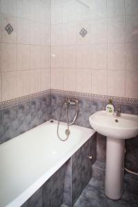 第聂伯罗Pobeda Apartment的浴室配有盥洗盆、浴缸和盥洗盆