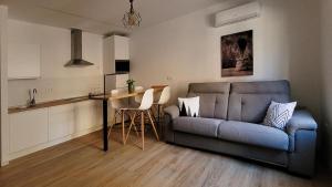 塞埃欣Parador 10 Apartamentos的一间带蓝色沙发的客厅和一间厨房