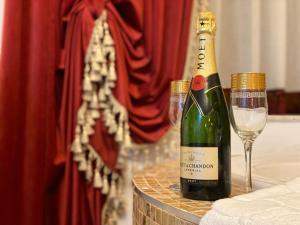弗格拉什Vila Imperial One Luxury Boutique Hotel的一瓶香槟和一张桌子上的葡萄酒杯