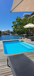 开普敦V&A Waterfront Marina Family Apartment 201 Altmore Cape Town的靠近水体的大型蓝色游泳池